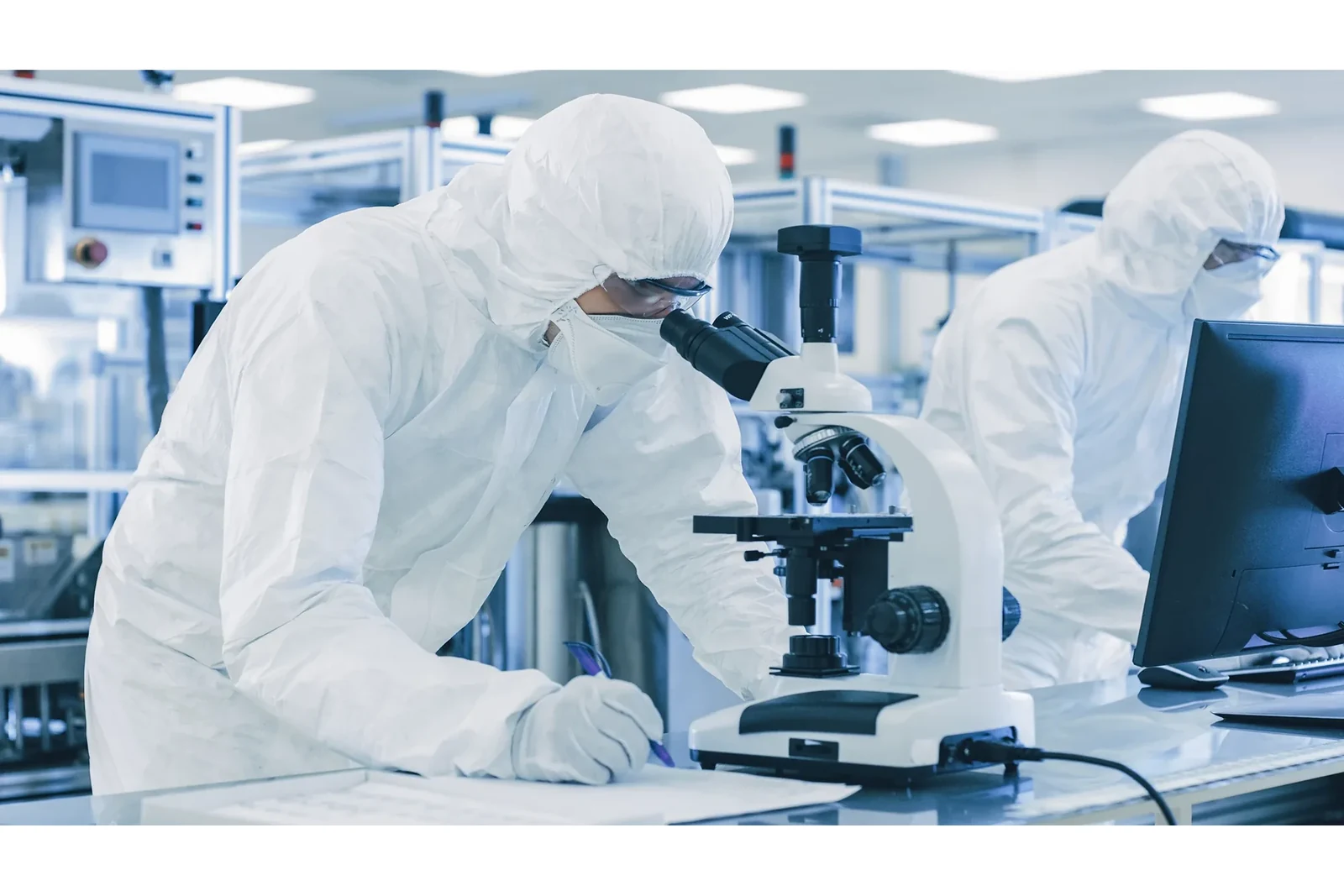 Same-site laboratory personnel examining material samples with a microscope