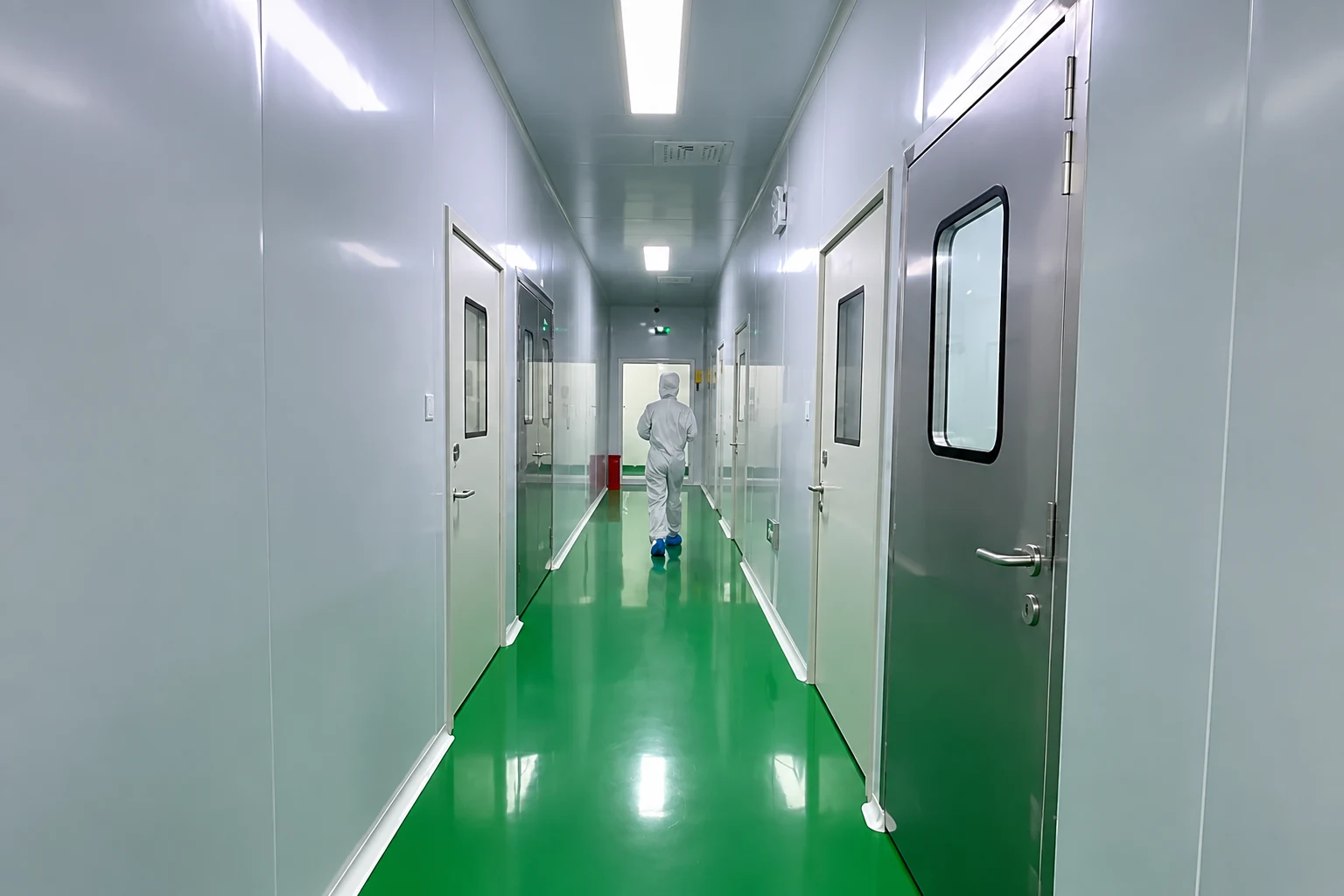 Green-floor corridor illustrating the boundary between production areas